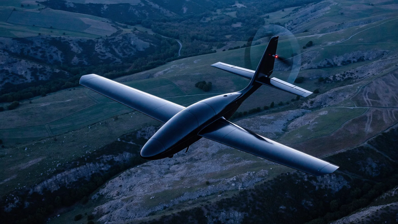 Illustration of a lightweight fixed-wing electric UAV flying above surveyed terrain